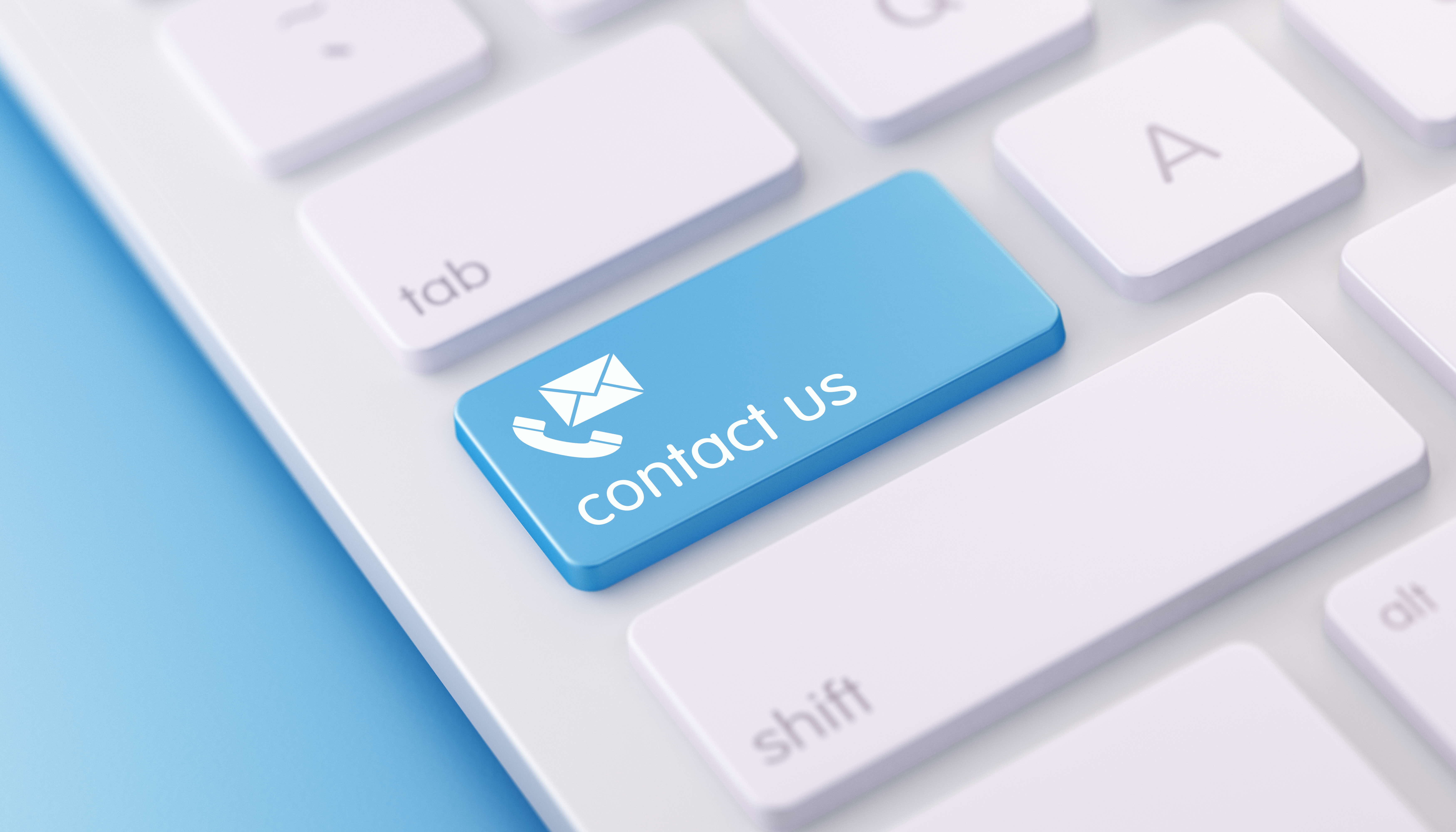 Blue 'contact us' key with envelope and hand icon on white computer keyboard